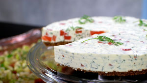 Smaskig "ostkaka" av gravad lax. Gravad lax "cheese cake" på serveringsfat.