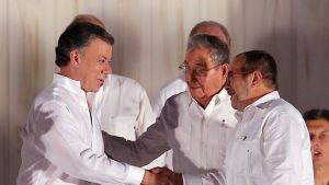 Colombias president Juan Manuel Santos och Farcledaren Rodrigo Londono Echeverri, alias "Timochenko" gratulerar varandra vid underteckningsceremonin. Kubas president Raul Castro följer med i bakgrunden. Colombias president Juan Manuel Santos och Farcledaren Rodrigo Londono Echeverri, alias "Timochenko" gratulerar varandra vid underteckningsceremonin. Kubas president Raul Castro följer med i bakgrunden