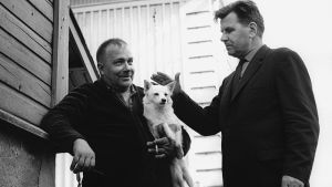 Viita jututtaa Pispalan asukkaita dokumentin teon lomassa Kirjailija Lauri Viita Pispalassa v. 1965, silittää miehen sylissä olevaa koiraa.