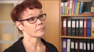 Ingås bildningschef Merja Olkinuora tror att det snart blir aktuellt att diskutera skolskjuts för barn i områden där det rör sig vargar. Kvinna med glasögon står vid en bokhylla med mappar.