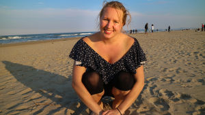 Linda vill inte säga vad som är rätt eller fel, hon vill bara att alla ska tänka till lite. Kvinna iklädd blommig klänning som sitter på en strand. I bakgrunden syns havet.