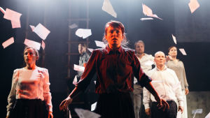 Maija Andersson omgiven av Outi Vuoriranta, Miika Laakso, Paavo Kerosuo, Jukka Pitkänen och Karoliina Kudjoi. Foto från Erottaja 1917-18 på Teater Avoimet Ovet.