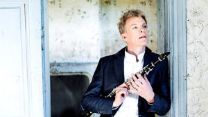 Solist Martin Fröst, klarinett Klarinettisten Martin Fröst står i en dörröppning och håller i sin klarinettt