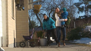 Belinda hämtar Hugo från familjedagvårdaren. Belinda hämtar hem sonen, bär honom i famnen.