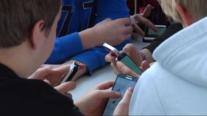 Åker mobiltelefonen fram också då du umgås med andra? Elever i Axxell med sina smarttelefoner.