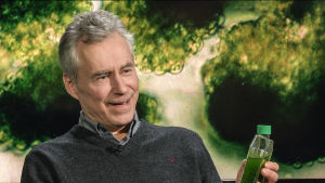 Professor Martin Romantschuk vid Helsingfors universitet. Algprovet han håller i handen är exempel på pågående forskning kring fettsyreframställning med hjälp av odlade alger. Professor Martin Romantschuk besökte Kvanthopps webbstudio och tog med sig ett antal algprover.