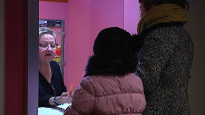 Anneli Halonen säljer biljetter vid Bio Forum. dam i biljettkassa med kunder