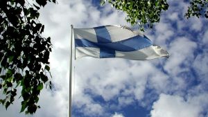 Suomen lippu liehuu taivasta vasten.