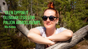 Mia Kotola nojaa kelohonkaan. Kuvassa teksti: "Olen oppinut olemaan itselleni paljon armollisempi.