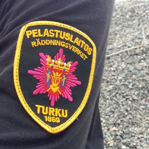 Närbild av ärmen på en brandman, räddningsverkets logga är insydd i skjortan. 