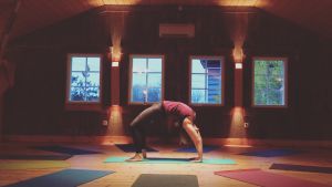 Ulrika Lillsunde utövar bland annat yoga. en kvinna som gör en brygga, yogaövning inne i en sal.