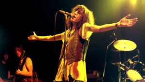 Patti Smith uppträder i Tyskland år 1978. Patti Smith uppträder år 1978. Hon sjunger vid mikrofonen med armarna usträckta åt sidorna.
