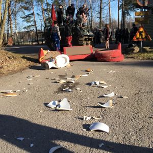 Spåren efter pansarvagnens framfart. En splittrad toalett och söndrig soffa framför en pansarvagn med studerande.