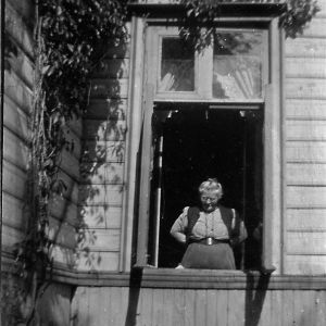 Helena Södergran vid den Södergranska villans fönster. Helena Södergran vid fönstret till den Södergranska villan.