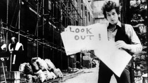 Don't Look Back. Bob Dylan esittelee sanakylttejä "musiikkivideossa" Subterranean Homesick Blues, taustalla Allen Ginsberg. Kuva D.A. Pennebakerin ohjaamasta dokumenttielokuvasta Don't Look Back (1967).