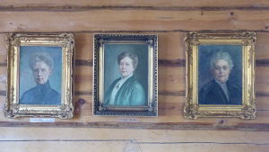 Fanny Tavaststjerna, Cely Mechelin och Vera Hjelt hänger ännu ihop i Villa Mechelin, numera som porträtt. Tre porträtt på en brun stockvägg. Oljemålningar som föreställer tre kvinnor; Fanny Tavaststjerna, Cely Mechelin och Vera Hjelt