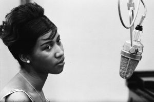Aretha Franklin slog igenom 1967 efter att ha bytt skivbolag från Columbia till Atlantic. Ungdomsporträtt av Aretha Franklin med studiomikrofon