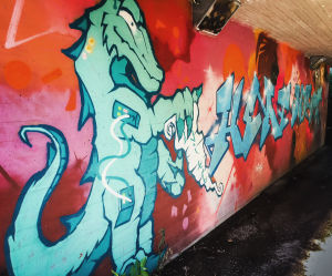 XX har målat i Myrbacka sedan 90-talet. Tack vare generalplanen finns det exceptionellt många gångtunnlar, alltså bra ytor för att måla. Graffititeos alikulkutunnelissa, jossa vihreäsävyinen lohikäärme.