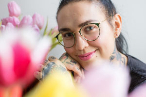 Natalia Tolmatsova katsoo kameraan, oikea käsi koskettaa leukaa.