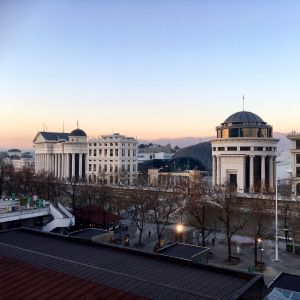 Byggnaderna på andra sidan floden Vardar är nya. Vy över floden Vardar i Skopje med nybyggda byggnader på andra sidan floden, byggda som en del av projektet Skopje 2014.