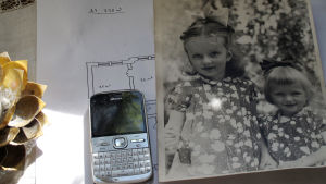 En gammal mobiltelefon och en gammal bild på systrarna.