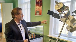 Juhani Huovelin invid en miniatyrmodell av Bepicolombo, i skala 1:10. Den riktiga sonden är sju meter lång och väger fyra ton. Juhani Huovelin invid en miniatyrmodell av Bepicolombo.