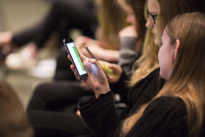 En testgrupp provade på utvärderingsappen på Ateneum under våren. två flickor ser på sina mobiltelefoner
