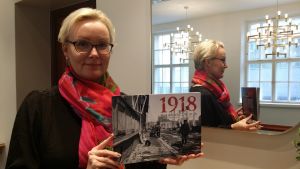 Första arkivarie Nelly Laitinen på SLS med den splitternya tvåspråkiga läroboken. Nelly laitinen sls