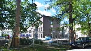 Klienter som behöver psykisk och psykiatrisk vård i Raseborg och övriga Västnyland ska få vård i det så kallade Psykecentret då det väl står färdigt. Ett hus i modern arkitektur och i en brungrå nyans som håller på att byggas. Runtom bygget går ett staket i metall och träd står inne på gården.