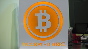 Skylt som visar att bitcoin accepteras som betalningsmedel. Skylt där det står att bitcoin accepteras som betalningsmedel.