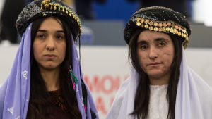 Nadia Murad och Lamiya Aji Bashar Nadia Murad till vänster, Lamiyja Aji Bashar till höger. De är klädda i yazidiernas traditionella dräkt med en slköja över huvudet samt ovanpå en hatt med guldslantar sydda runt brättet.