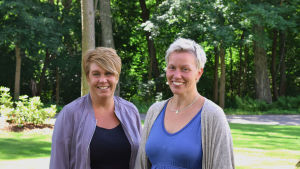 Monica Kainulainen och Bodil Strandström jobbar med missbruk. Två kvinnor står leende. I bakgrunden syns skog.