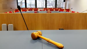 Ålands Tingsrätt ser befälhavarens brott som ringa och utföser ingen straffpåföljd. En rättssal, bilden tagen från domarens perspektiv. I förgrunden en domarklubba.