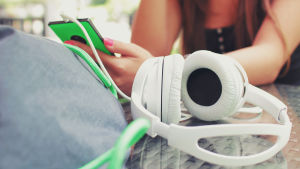 De som jobbar med turismmarknadsföring hoppas speciellt nå den yngre generationen via bloggarna. Flicka med mobiltelefon och hörlurar.