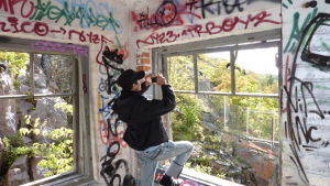 Man får inte fotografera var som helst utan måste ibland be om lov. En kille som fotograferar klotter inne i ett övergivet hus.