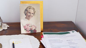 I sovrummet samsas Ann Nymalms konfirmationsfoto med Deboras kontaktuppgifter. Ann Nymalm som konfirmand - och Deboras papper