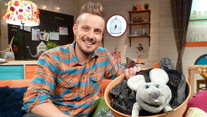 Jonathan "Jontti" Granbacka och Plåstret får snart semester! BUU-klubbsledaren Jontti Granbacka sitter i soffan i buuklubbsrummet tillsammans med handdockan Plåstret