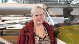 Tanken på vad som händer om Malms flygplats verkligen stänger gör Gun Gustavsson allvarlig. Gun vid ett flygplan i hangar på malms flygplats