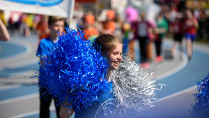 Fint väder för pom-poms på stafettkarnevalen! Inmarschen på stafettkarnevalen. Flicka med pom-poms