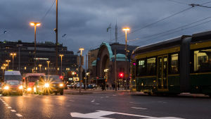 I centrum förekommer droghandel. Autoja ajaa iltahämärässä valot päällä.