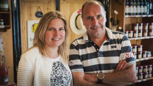 Vaalea nainen valkeassa puserossa, tummahko mies raidallisessa t-paidassa.