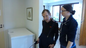 Karl-Rune Granqvist får stöd av fysioterapeuten Karoliina Saari. En fysioterapeut hjälper en äldre man att gå med rollator.