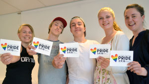 Bakom bloggen står Yle Västnylands Malin Valtonen tillsammans med ungdomarna Isak Slöör, Emil Thuesen, Isabelle Hyytiäinen samt ungdomssekreterare Fredrika Åkerö. På bilden fattas Emilie Jäntti. Malin Valtonen, Isak Slöör, Emil Thuesen, Isabelle Hyytiäinen och Fredrika Åkerö håller i kort där det står Raseborg Pride.