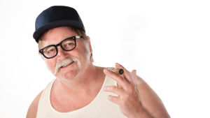 "Jag har både klass och bor på landsbygden, vad är problemet?" Vit man med mustasch i wifebater-undertröja med keps och cigarr. En så kalad redneck.