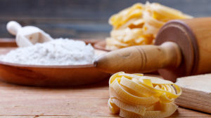 I mars blir det enbart glutenfri tagliatelle för Jenny. Pasta (tagliatelle), en kavel och i bakgrunden ett fat fyllt av vitt vetemjöl.