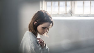 Linda sitter på kåken Fången ;Linda i sin cell i vitt ljus i isländska tv-serien Fångar