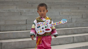 En liten pojke med sin leksaksgitarr i Nordkoreas huvudstad Pyongyang 2011. En liten pojke med leksaksgitarr i Pyongyang i Nordkorea