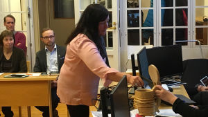Samlingspartiets Sari Wilhola röstar. En personer lägger en röst i en valurna.