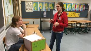 Sonja Kotakallio har organiserat ungdomsvalet i Kyrkslätts gymnasium. Abiturienten Lukas Lindroth är valfunktionär. Två personer talar med varandra.