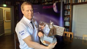 Juhani Huovelin poserar med SIXS. Instrumentet är stort som en skolåda och väger ett par kilogram. Det finländska SIXS-instrumentet.